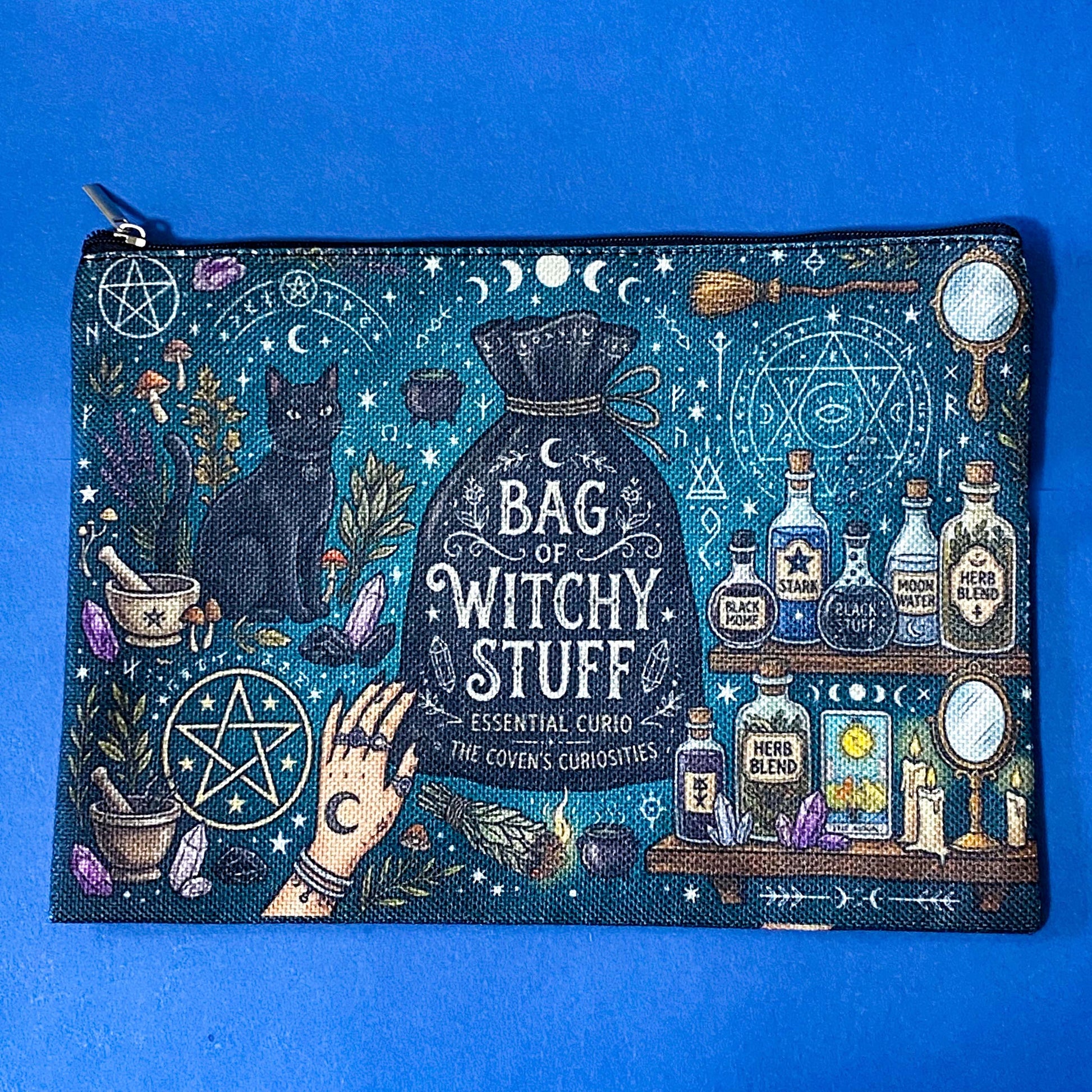 black cat apothecary zip pouch featuring witchy illustrations including a black cat potion bottles, crystals, herbs and moon phases. Teal and black fabric cosmetic bag. 