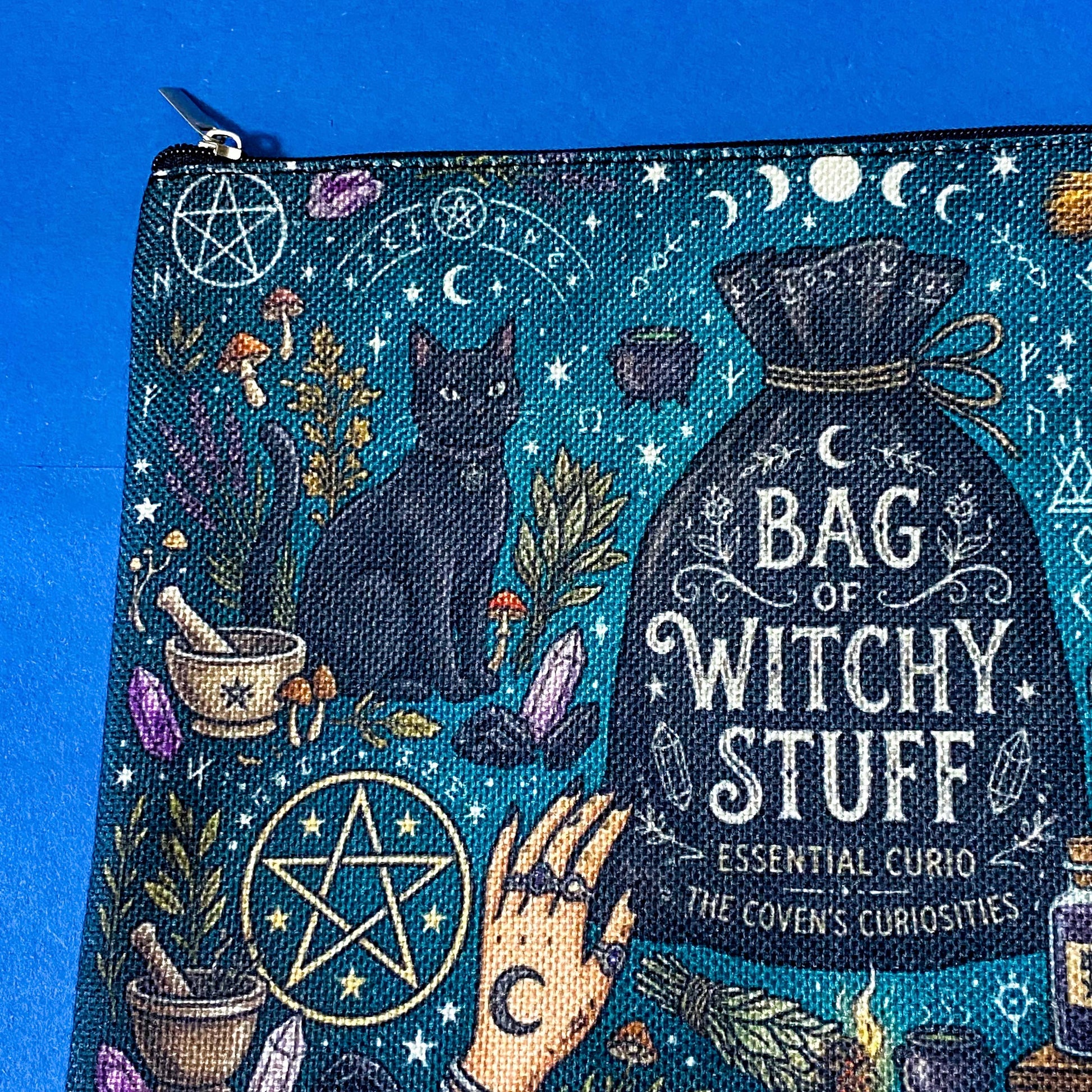 black cat apothecary zip pouch featuring witchy illustrations including a black cat potion bottles, crystals, herbs and moon phases. Teal and black fabric cosmetic bag. 