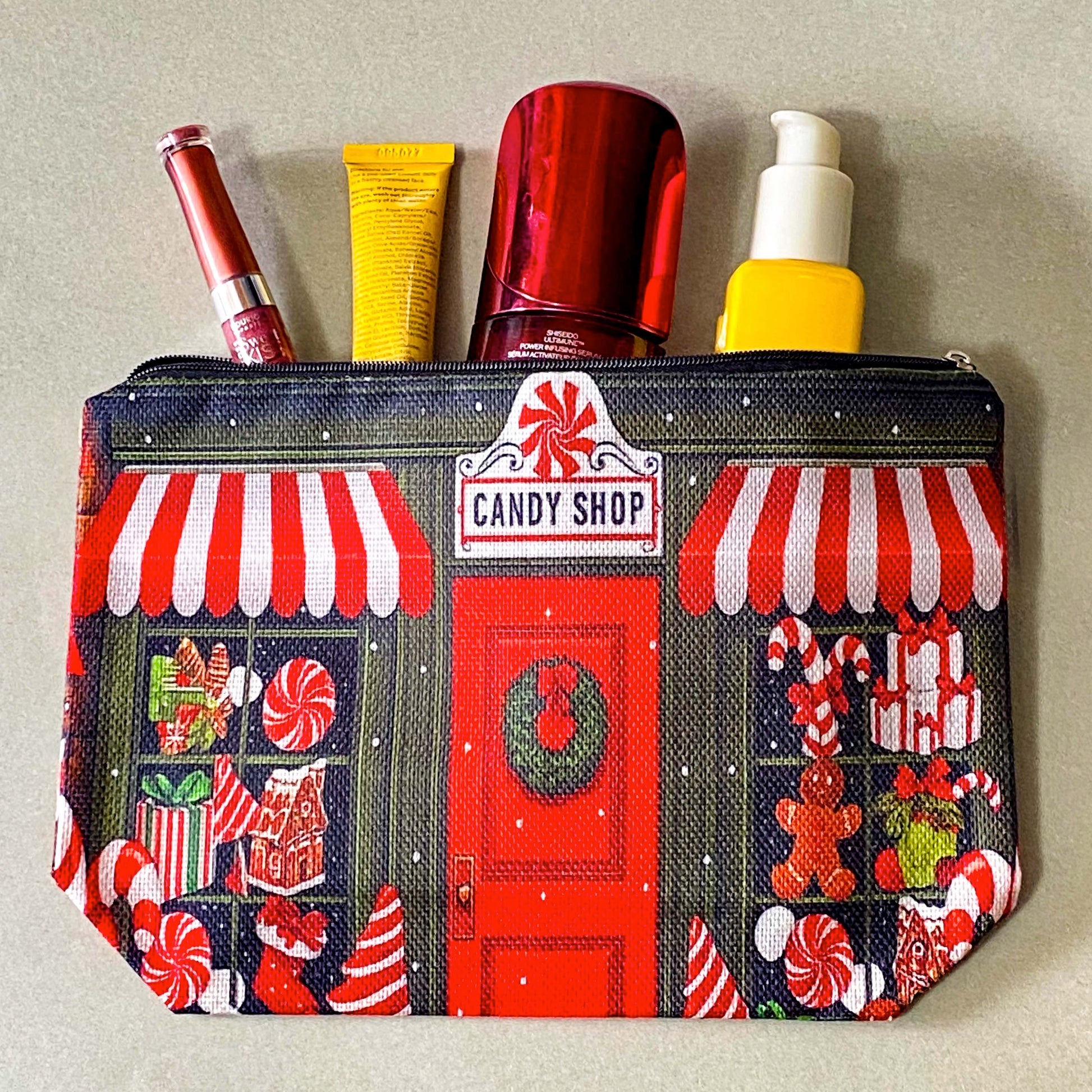 christmas candy shop vintage style woven canvas zip pouch featuring a festive sweet shop front with red and white striped awnings, a wreath covered door and gifts and toys in the windows. fun Christmas cosmetic bag or gift.