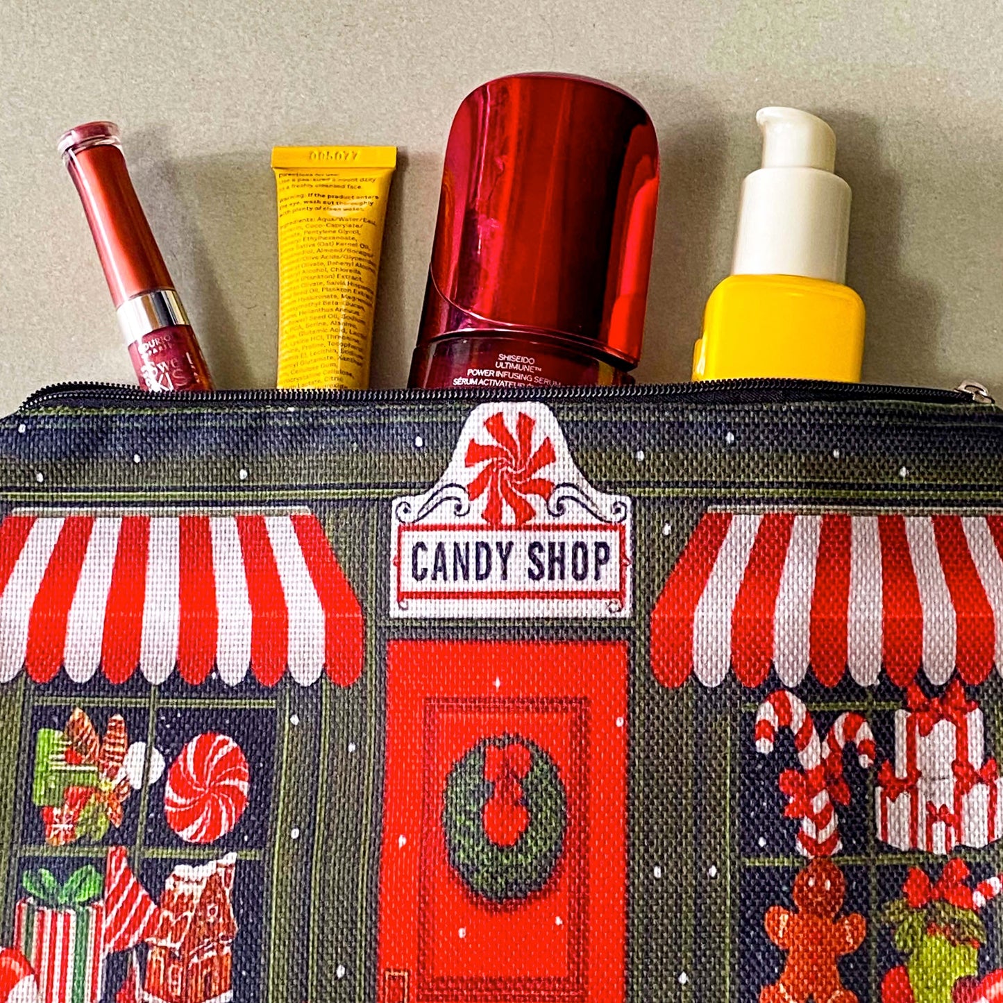 christmas candy shop vintage style woven canvas zip pouch featuring a festive sweet shop front with red and white striped awnings, a wreath covered door and gifts and toys in the windows. fun Christmas cosmetic bag or gift.