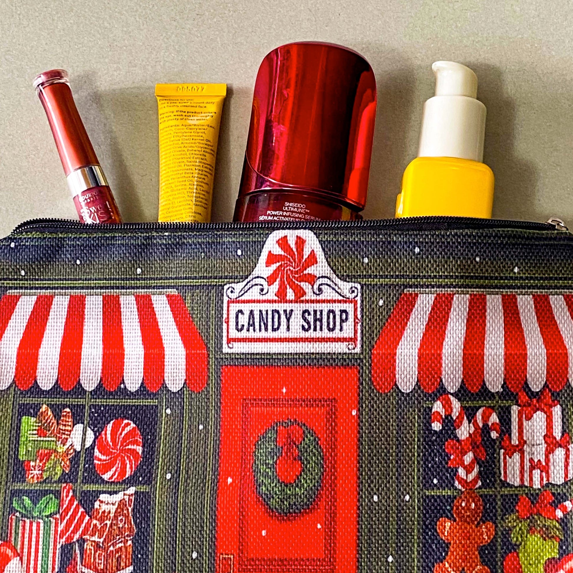 christmas candy shop vintage style woven canvas zip pouch featuring a festive sweet shop front with red and white striped awnings, a wreath covered door and gifts and toys in the windows. fun Christmas cosmetic bag or gift.