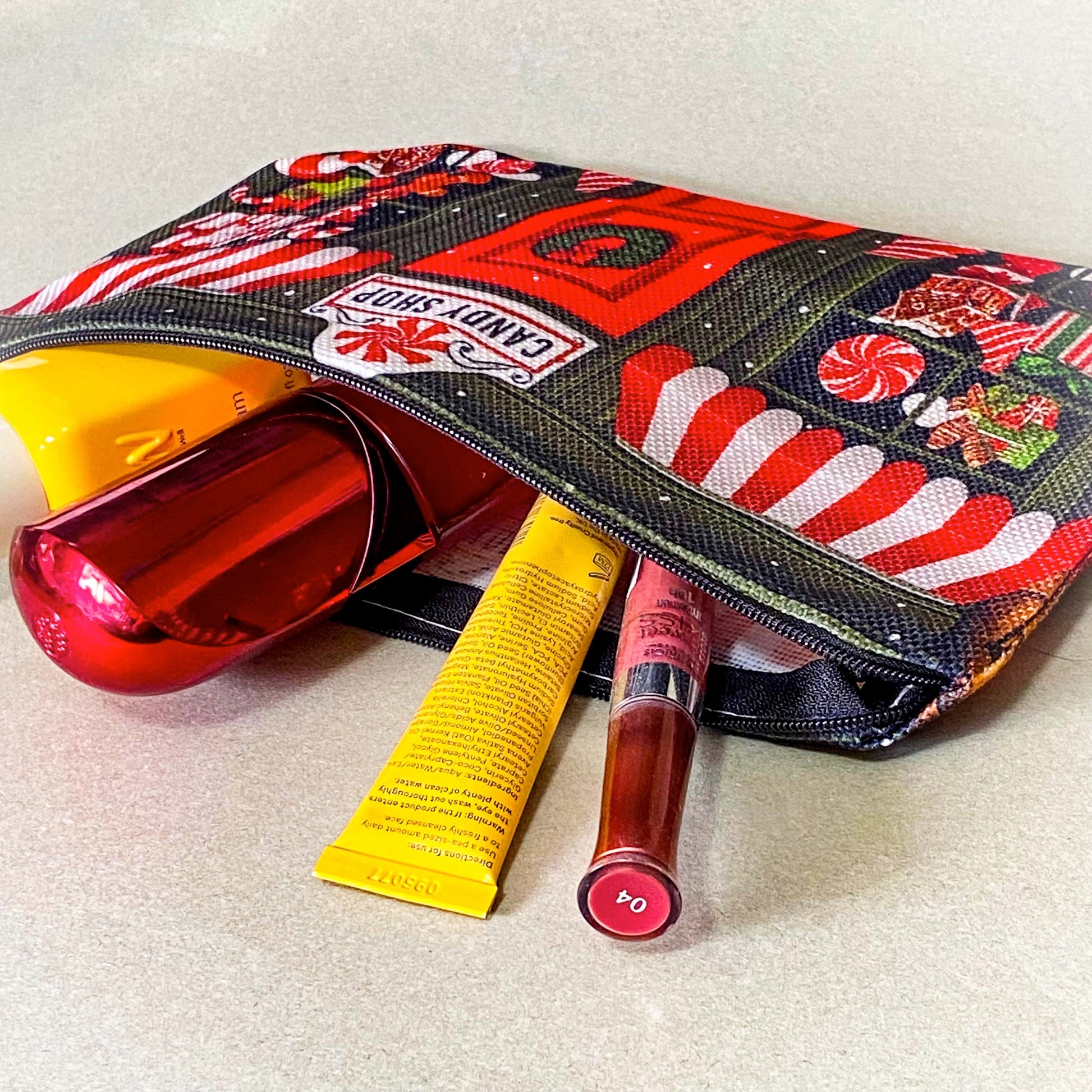 christmas candy shop vintage style woven canvas zip pouch featuring a festive sweet shop front with red and white striped awnings, a wreath covered door and gifts and toys in the windows. fun Christmas cosmetic bag or gift.