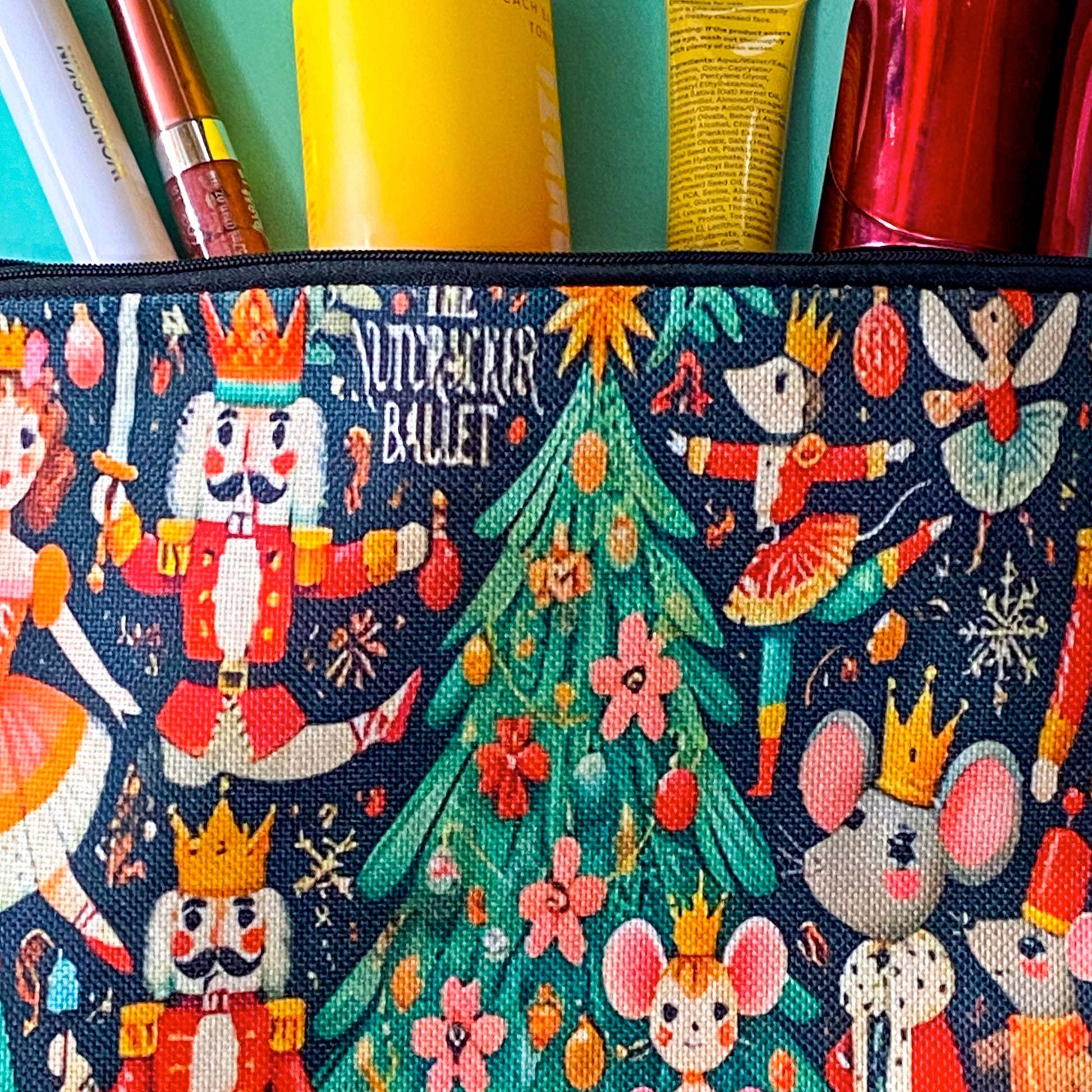 large woven nutcracker ballet zip canvas pouch featuring ballerinas, royal nutcrackers, dancing mice, a decorated Christmas tree and festive illustrations on black background