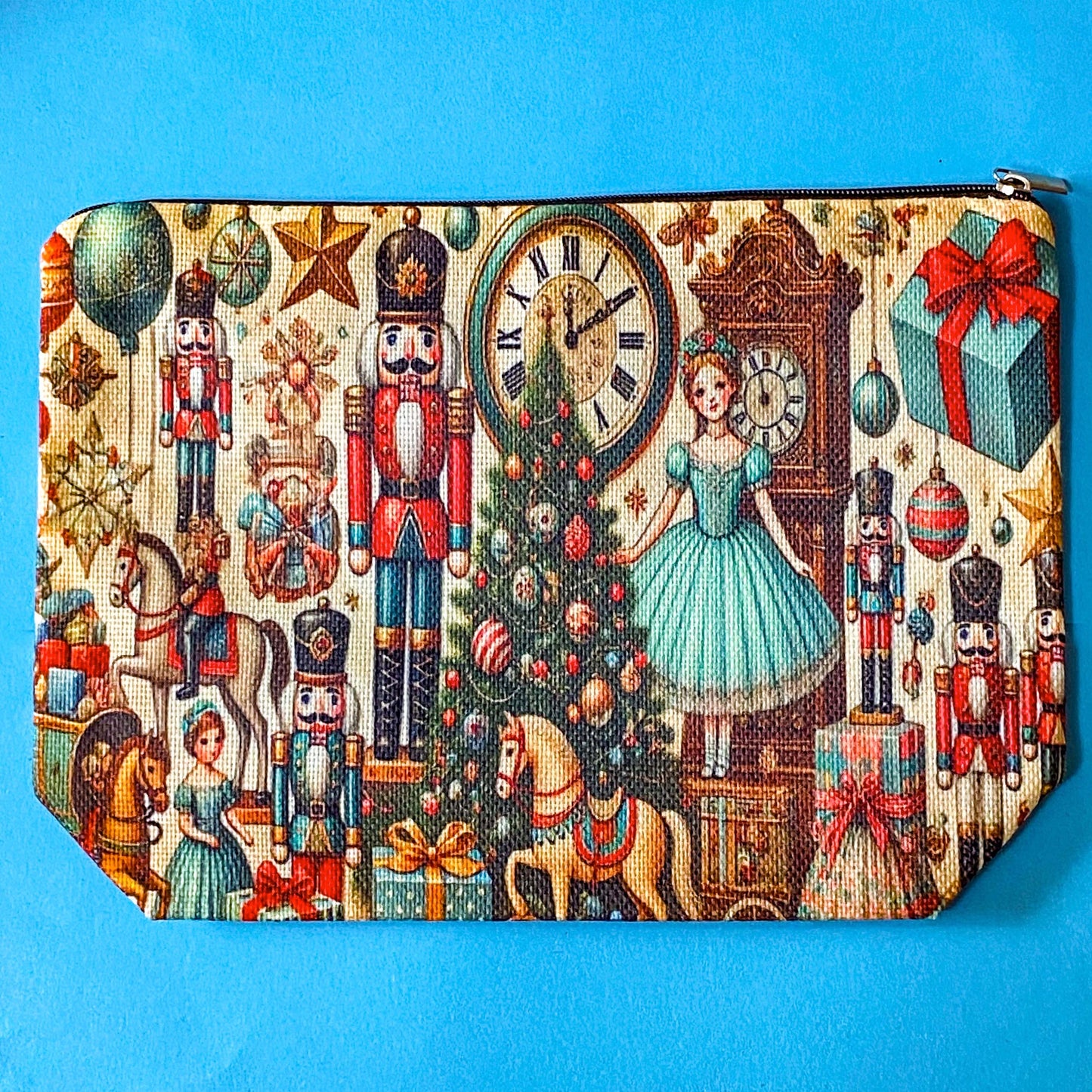 woven festive Christmas zip pouch featuring the nutcracker suite design with christmas tree, antique clocks rocking horses, ballerina, toys and presents on a cream fabric background.