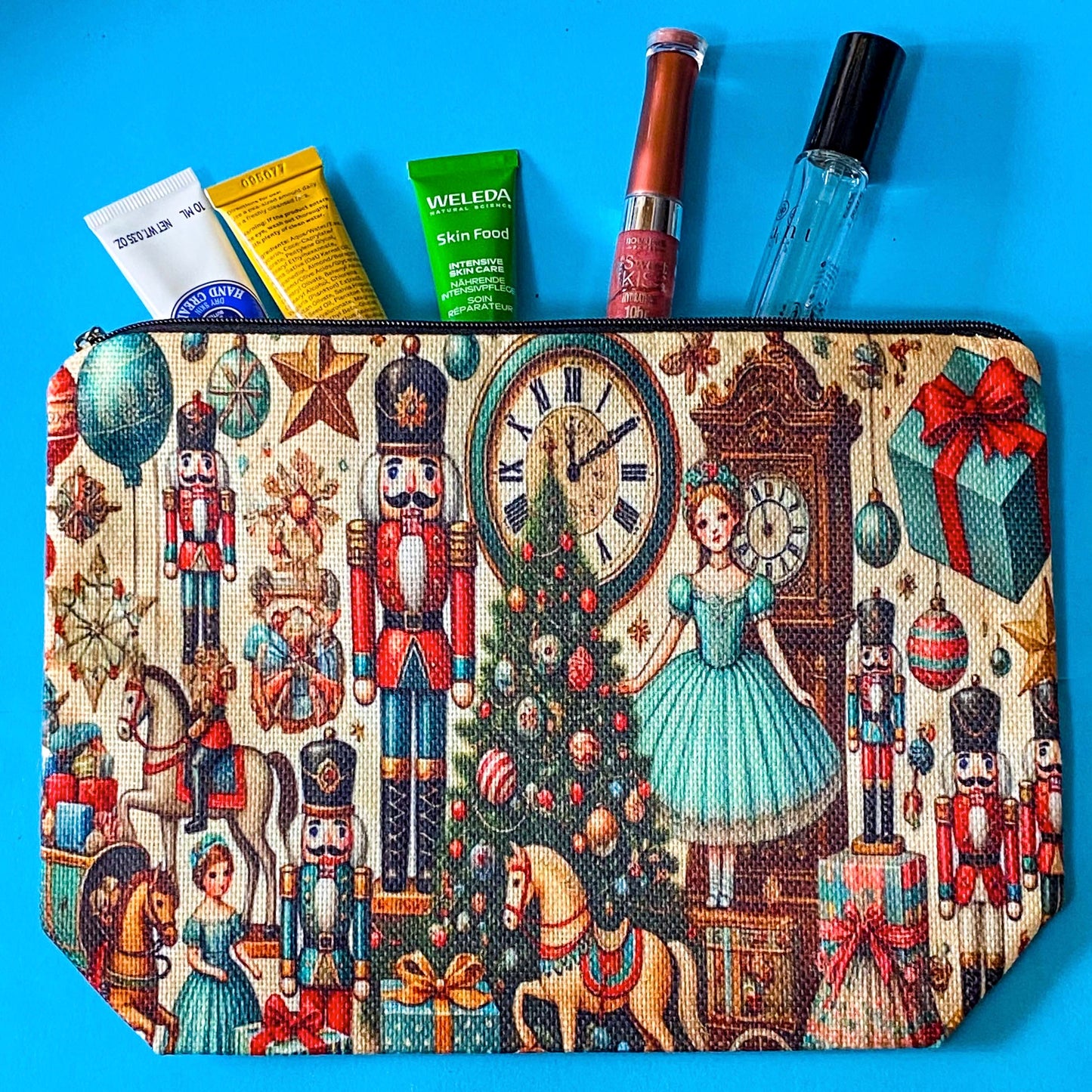 woven festive Christmas zip pouch featuring the nutcracker suite design with christmas tree, antique clocks rocking horses, ballerina, toys and presents on a cream fabric background.