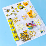 craft bundle in a bee and daisy theme with grosgrain ribbon, buttons, flatbacks, charms and beads on a blue background