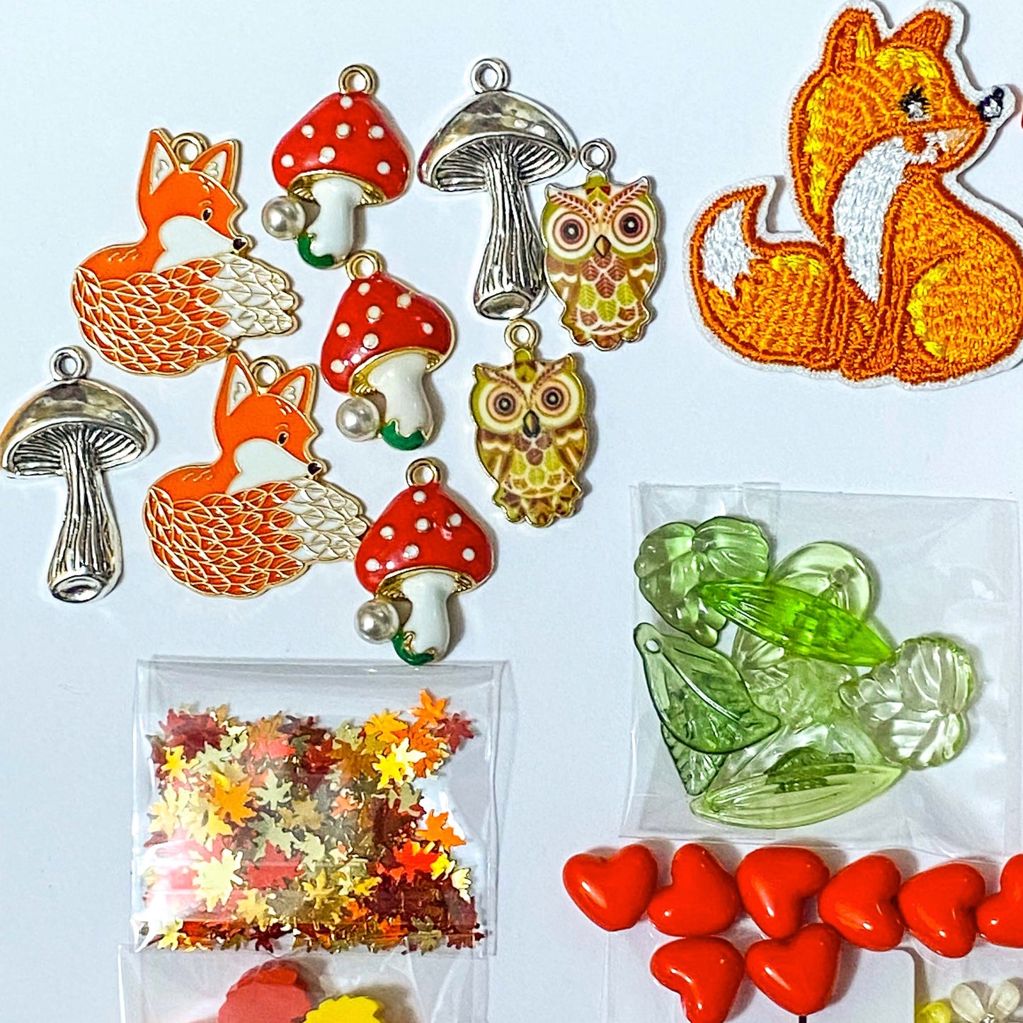 autumn fox craft bundle with grosgrain ribbon, beads, enamel charms, sequins and buttons in a cellophane pack on a white background