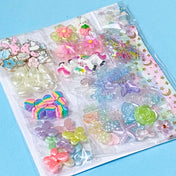 craft bundle with a kawaii cute pastel theme with beads, flatbacks, enamel charms, sequins and ribbon on a blue background