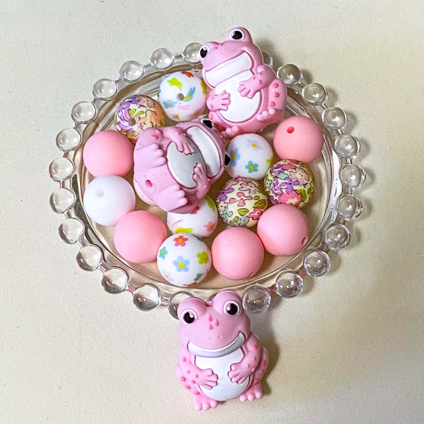 bundle of pretty pink frog silicone beads with focal 33mm frog bead and 7 other plain and patterned beads in floral pinks and white. uk craft supplies shop.