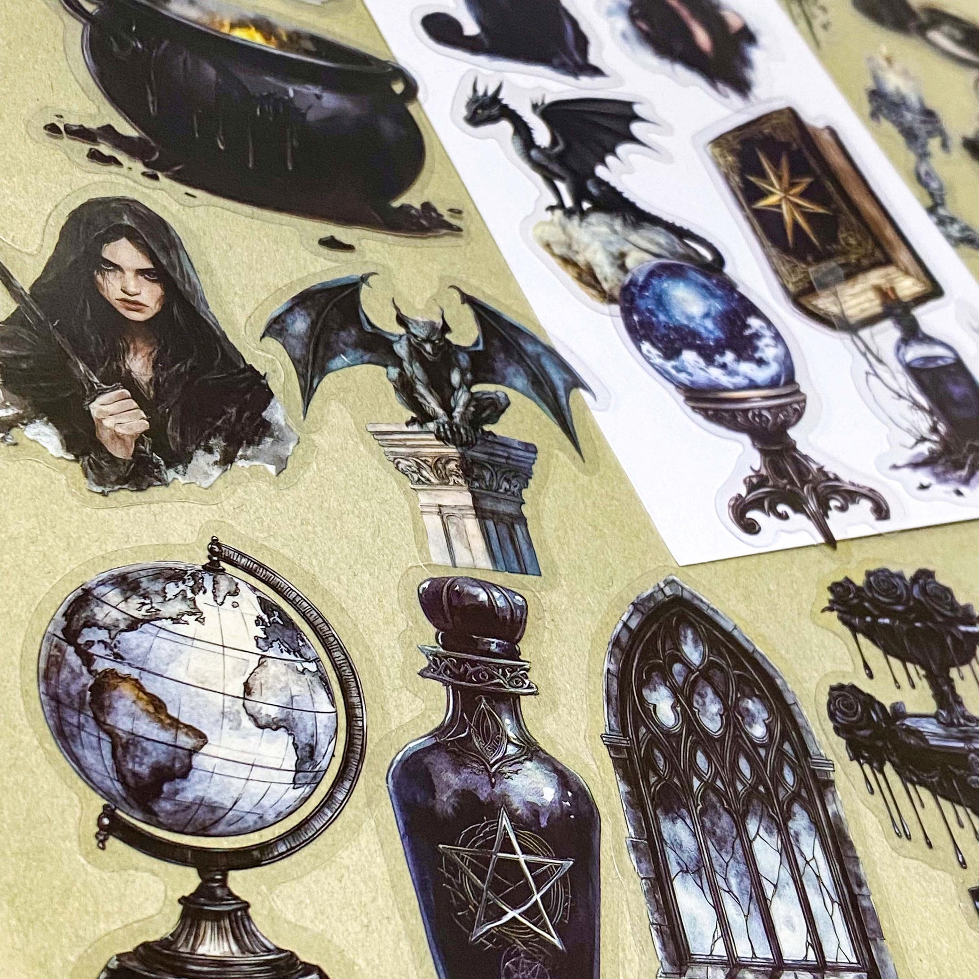 shadow gothic black and dark academia witchy gothic pet stickers pack of 50 with candles, ravens, black cats, hats, crystals, teapots, bats, griffins, potions, spell books. large 70mm clear plastic sticker pack.