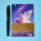 set of 4 fantasy postcards featuring fairy, unicorn and celestial night scenes in soft pastel tones, arranged with pen for scale and wrapped with kraft belly band and wax seal