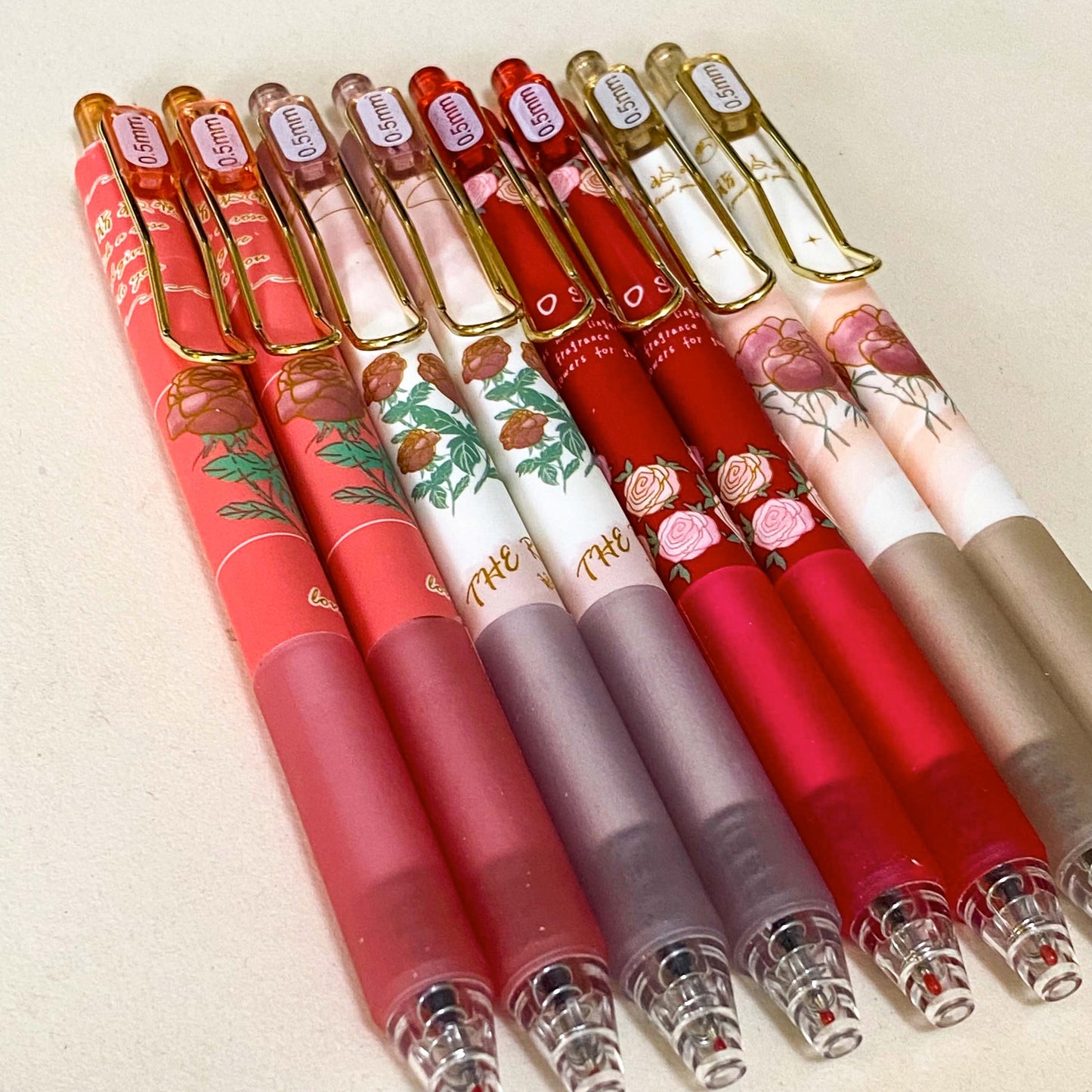 set of floral gel pens 0.5mm nib with vintage rose and botanical designs in red, pink and cream tones with gold clips