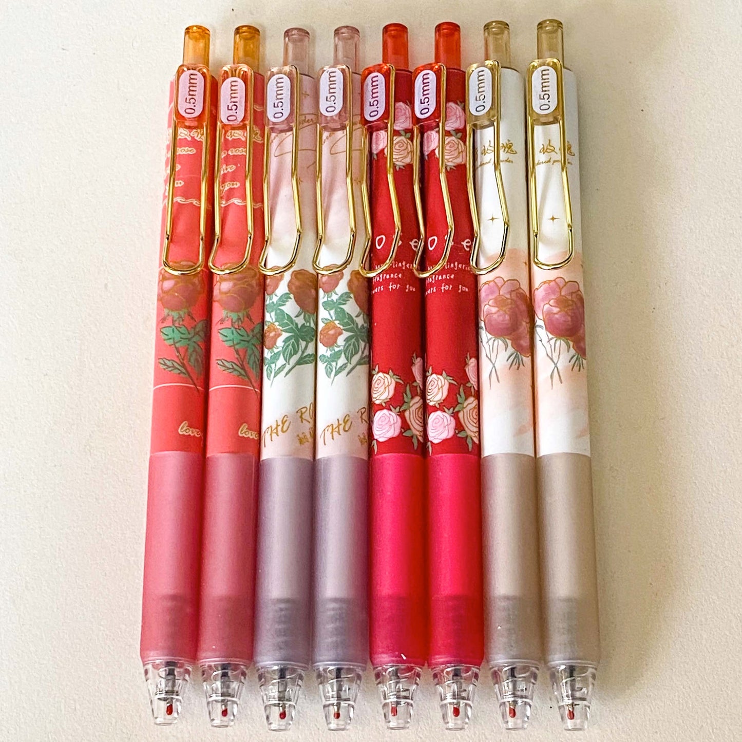set of floral gel pens 0.5mm nib with vintage rose and botanical designs in red, pink and cream tones with gold clips