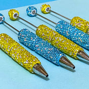 sparkly rhinestone encrusted lemon yellow and turquoise blue pen blanks for making beaded pens on a blue background