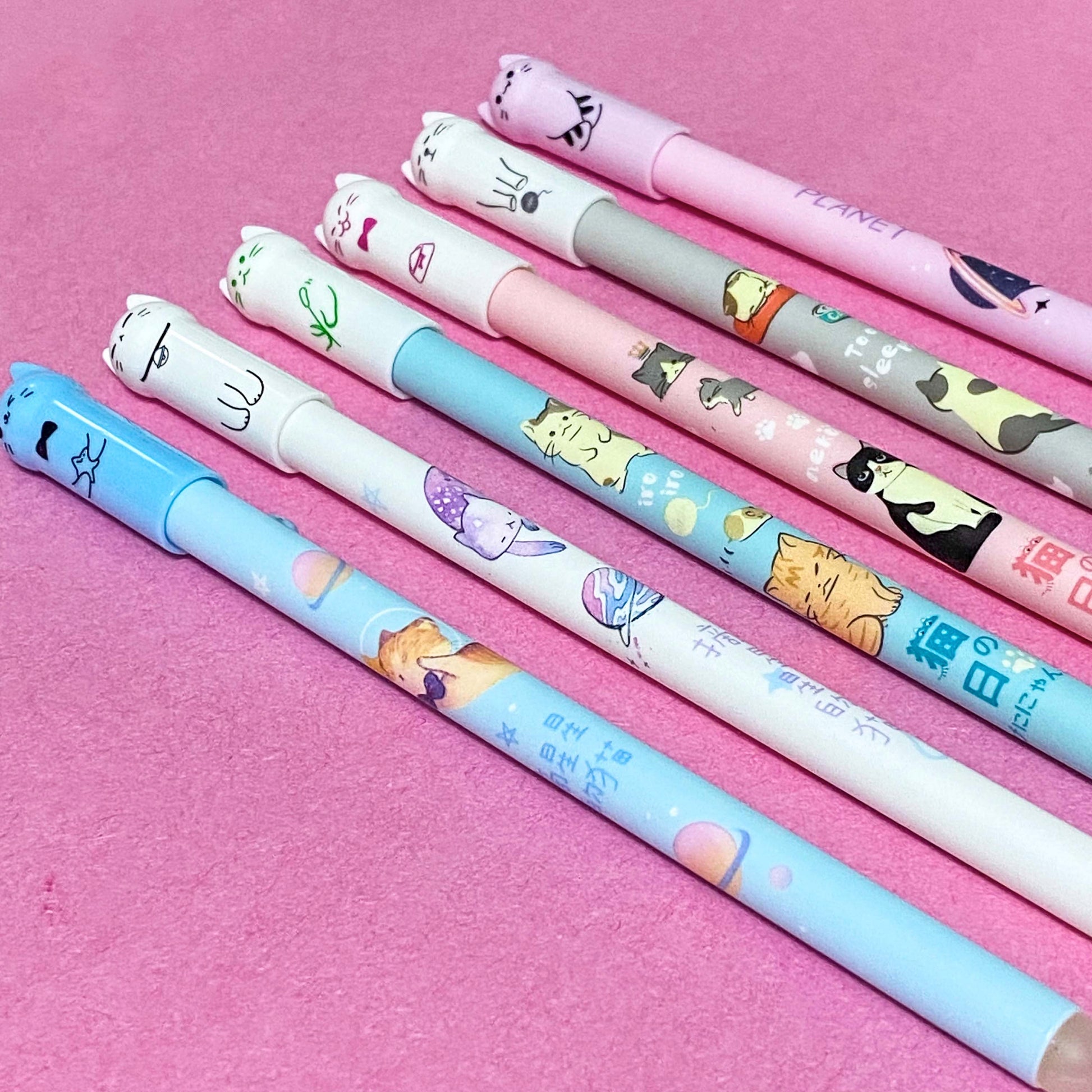 slim kitty pens with pastel coloured barrels and cute faces on a pink background