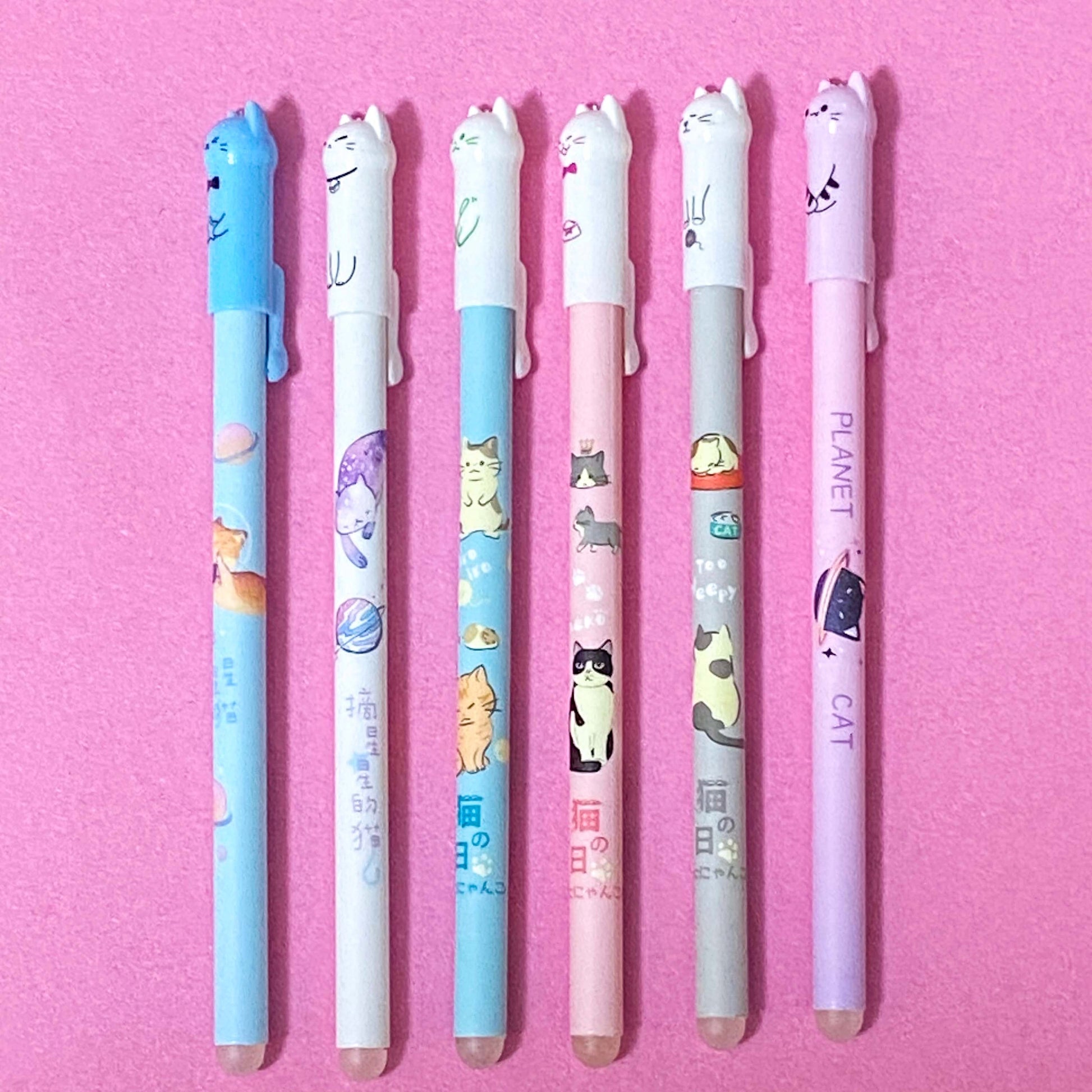 6 pretty slim cat blue ink pens with pastel colours on a pink background
