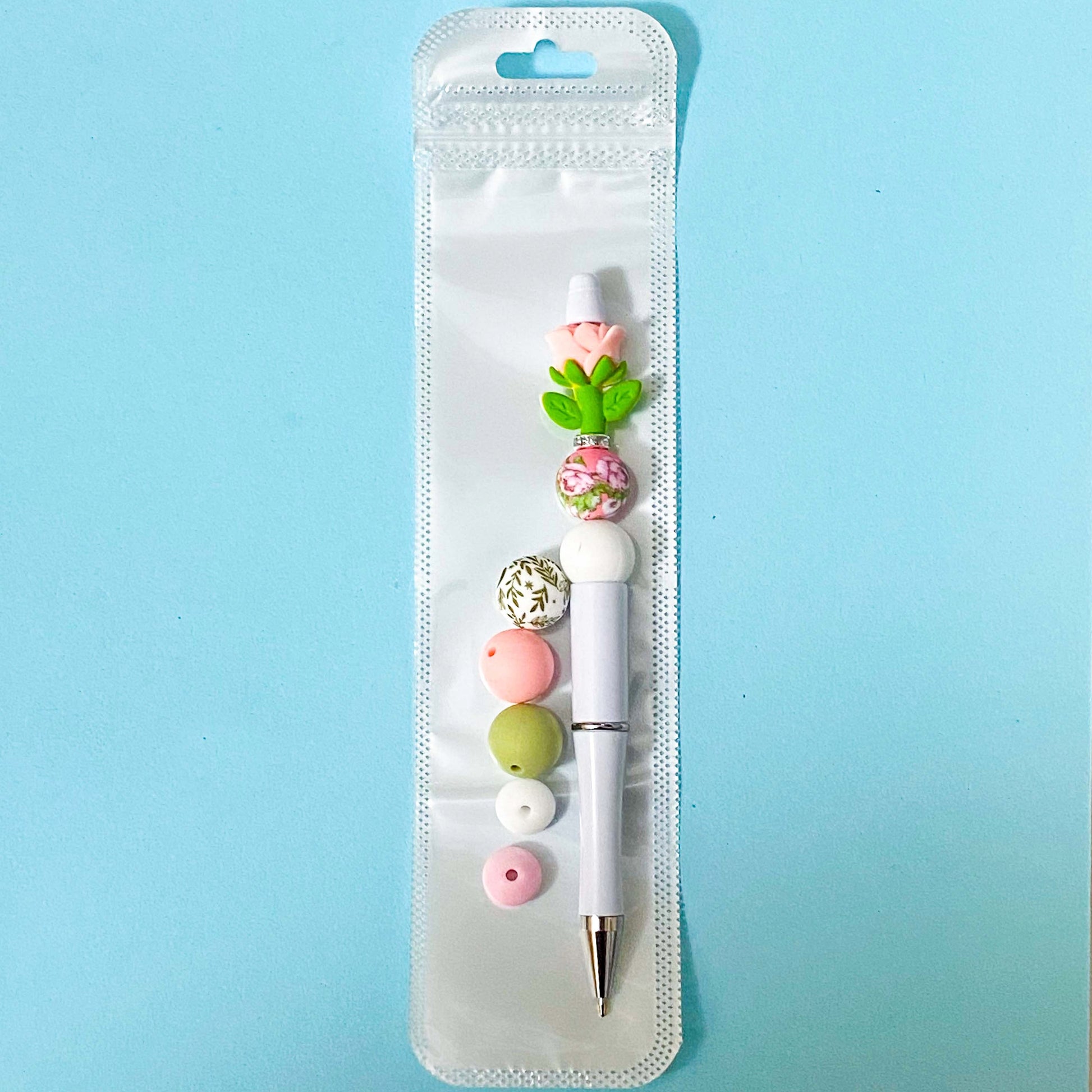 pink rose beaded pen spring diy kit in holo bag with extra beads on blue background
