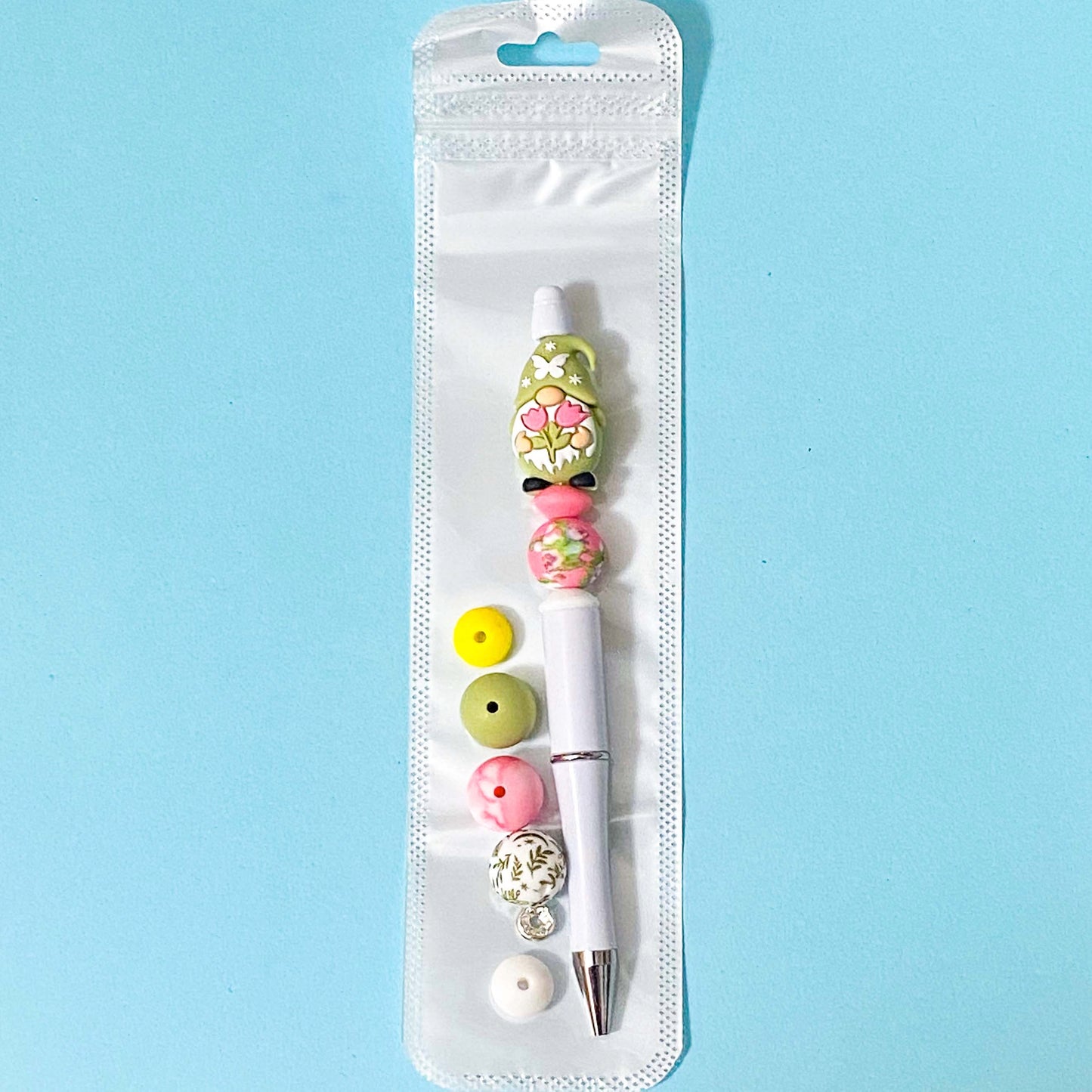 sage green spring gnome beaded pen kit with extra silicone beads on a blue background