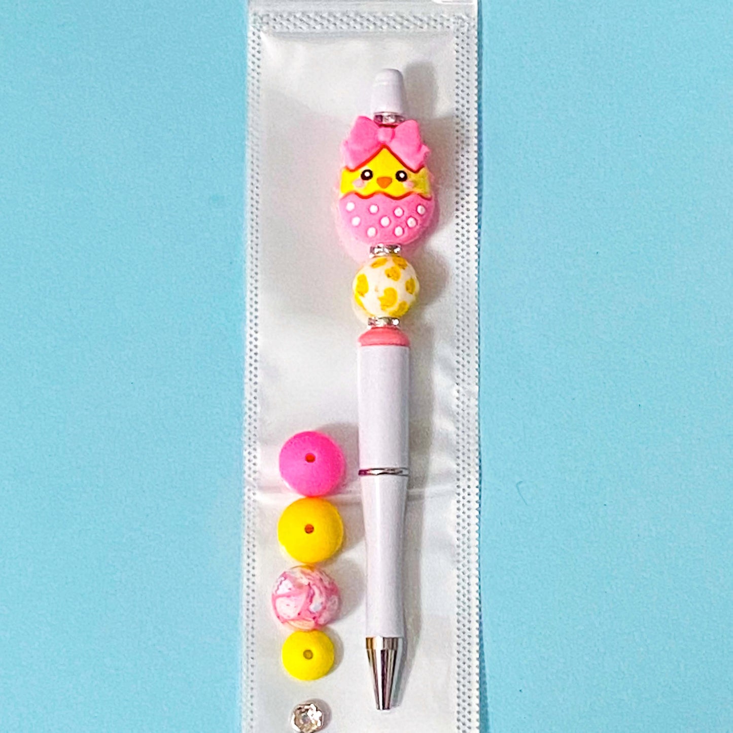 hot pink and yellow chick silicone bead pen diy kit on blue background