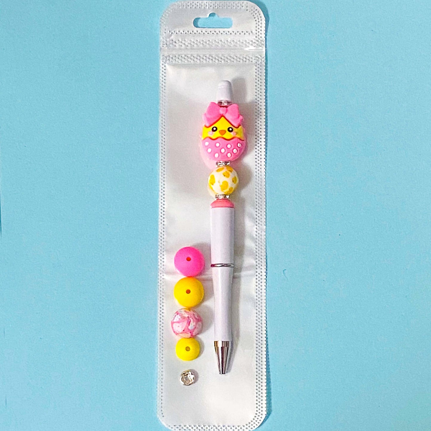 hot pink and yellow chick silicone bead pen diy kit on blue background