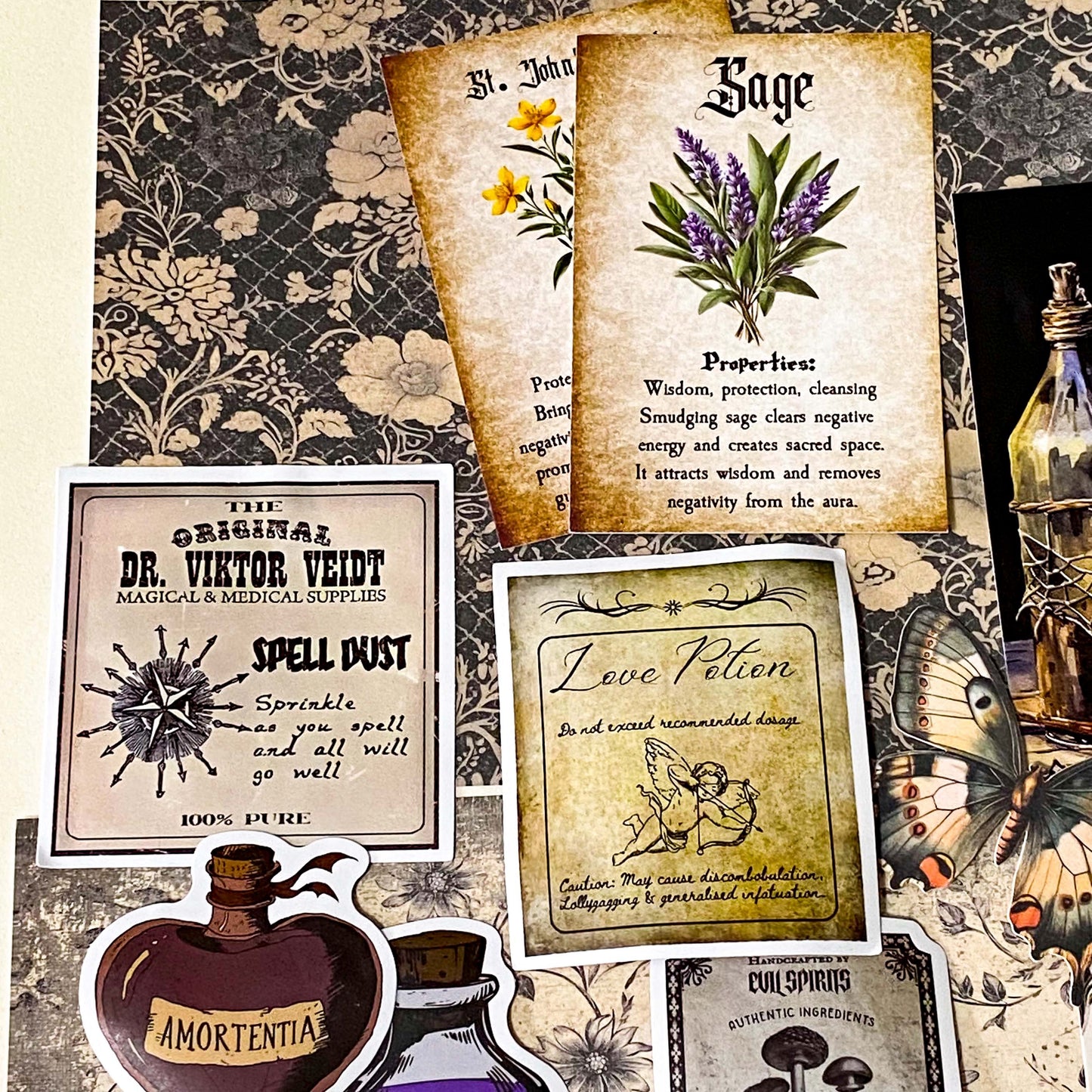 witchy apothecary ephemera bundle with potion vial, vintage herb cards, gothic stickers, insect illustrations and scrapbook papers arranged on botanical background