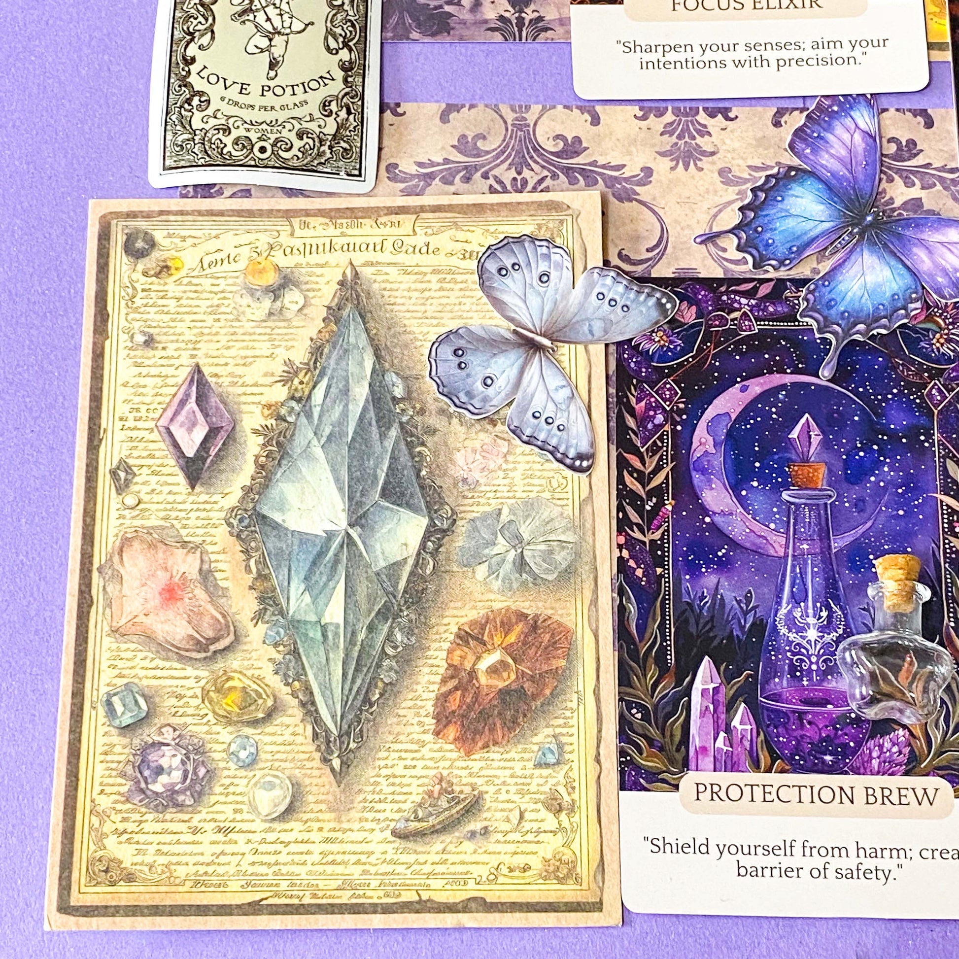 witchy potion oracle journalling kit with purple scrapbook papers, gothic prints, stickers, butterfly and beetle die cuts and mini glass vial jar