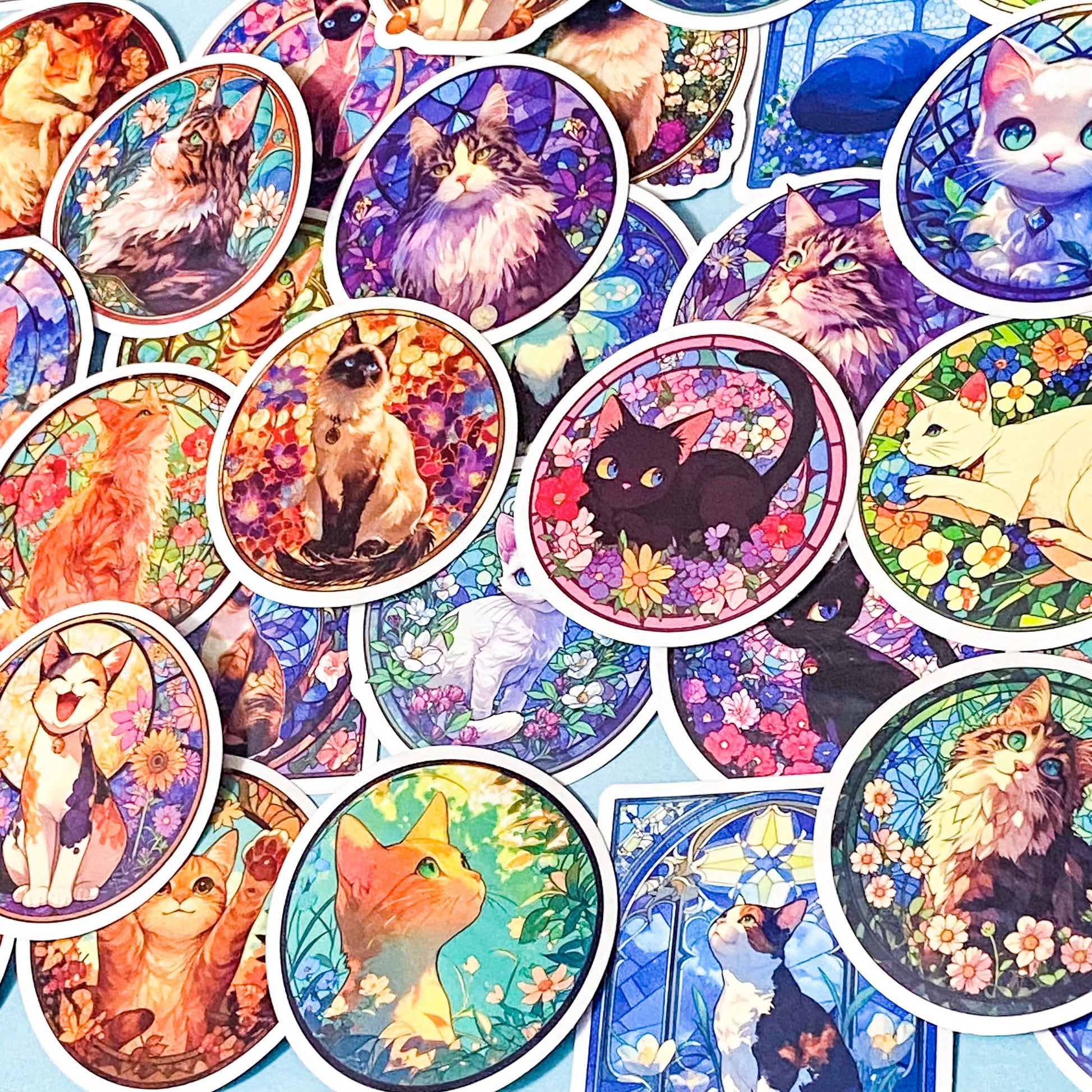 Collection of colorful cat-themed stained glass window stickers on a blue background