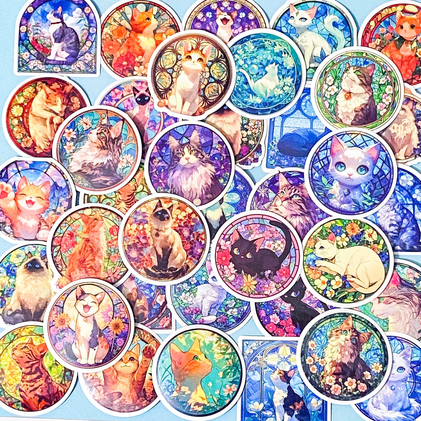 Collection of colorful cat-themed stained glass window laptop stickers on a blue background