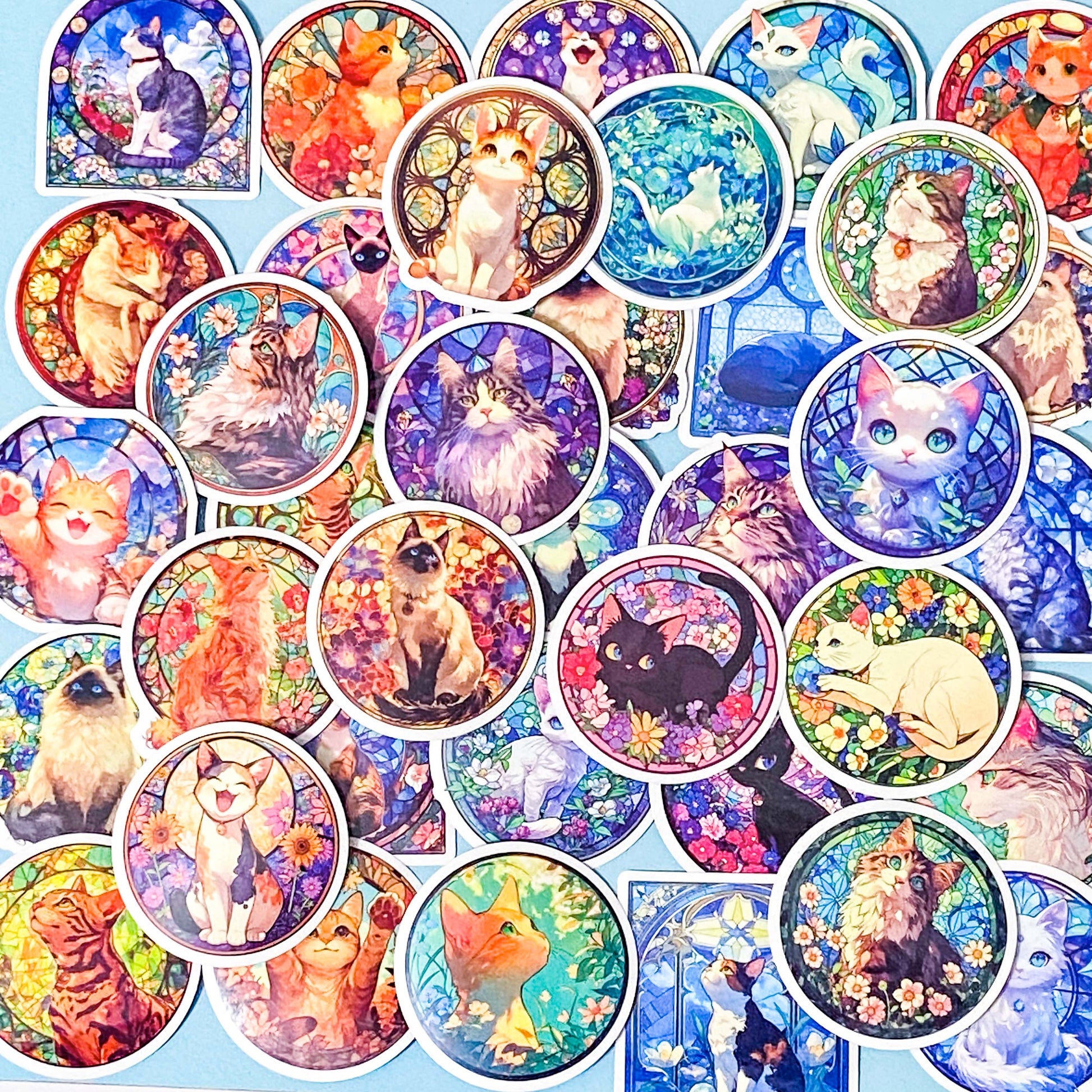 Collection of colorful cat-themed stained glass window laptop stickers on a blue background