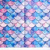 Pattern of blue, pink, and purple fish scales on sheets of tissue paper on a white background