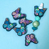 very large 30mm silicone butterfly beads in purple and teal floral pattern on a blue background