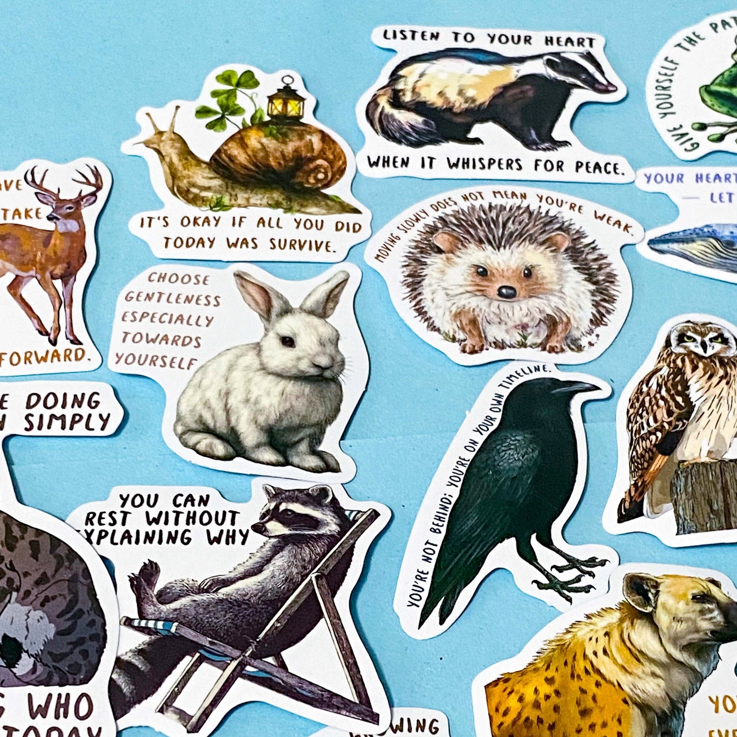 set of 50 animal positive quote stickers with affirmations featuring illustrated wildlife including badgers, hedgehogs, deer, snails and birds on a soft blue background