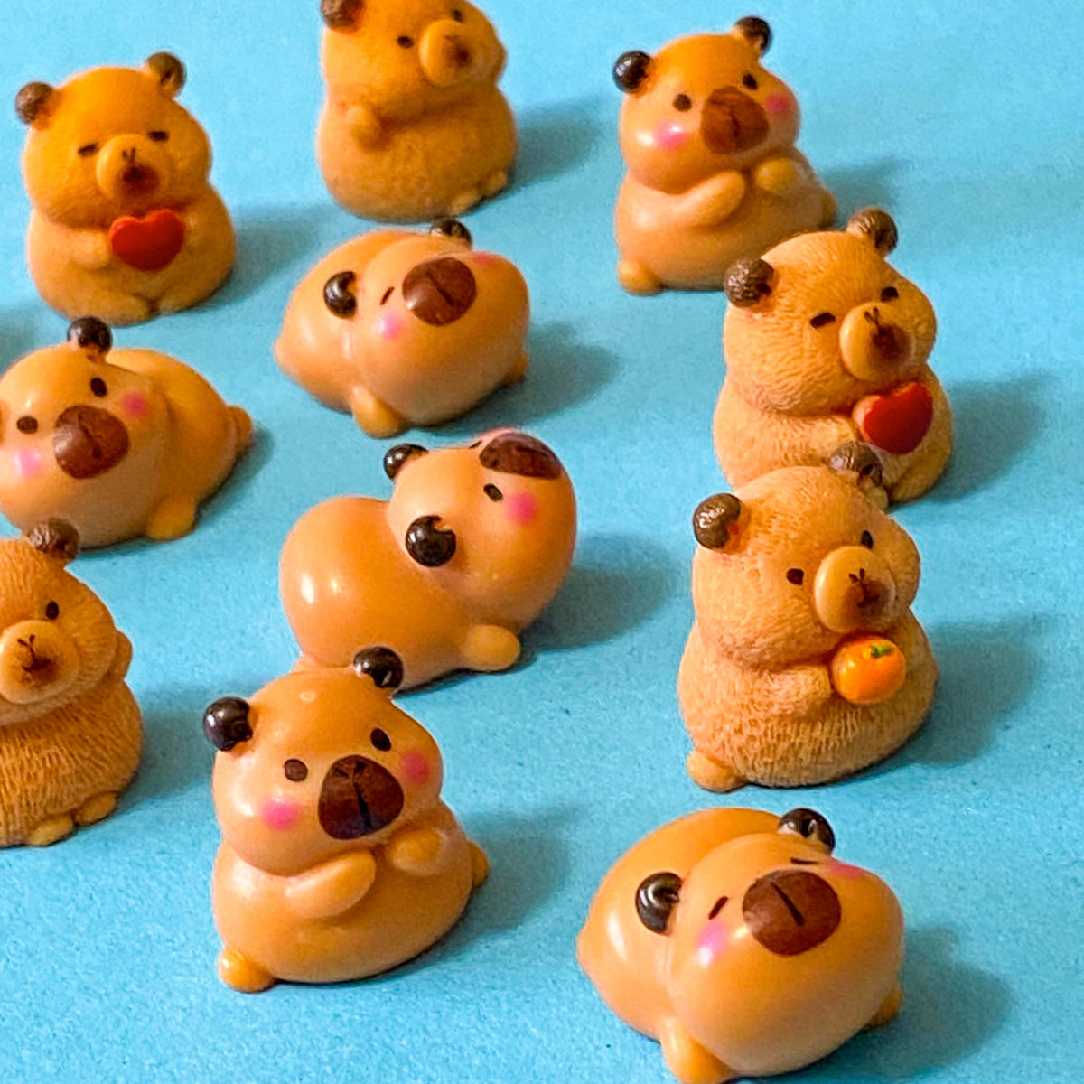 resin 3D miniature capybara figurines with oranges, hearts and cute expressions. Set of 3 different animals i9n organza bag