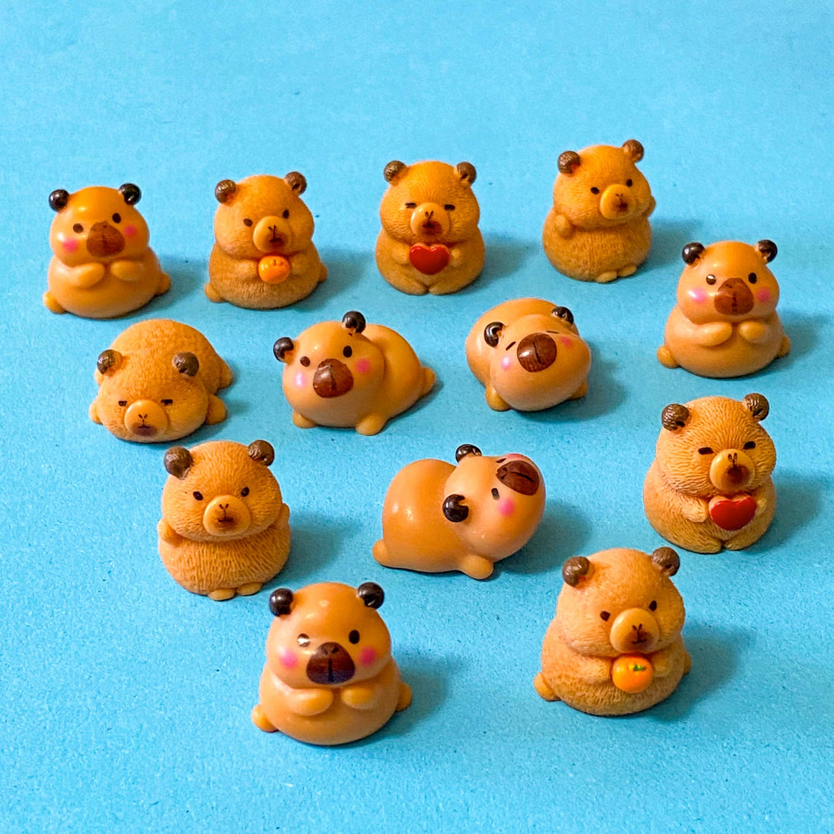 resin 3D miniature capybara figurines with oranges, hearts and cute expressions. Set of 3 different animals i9n organza bag