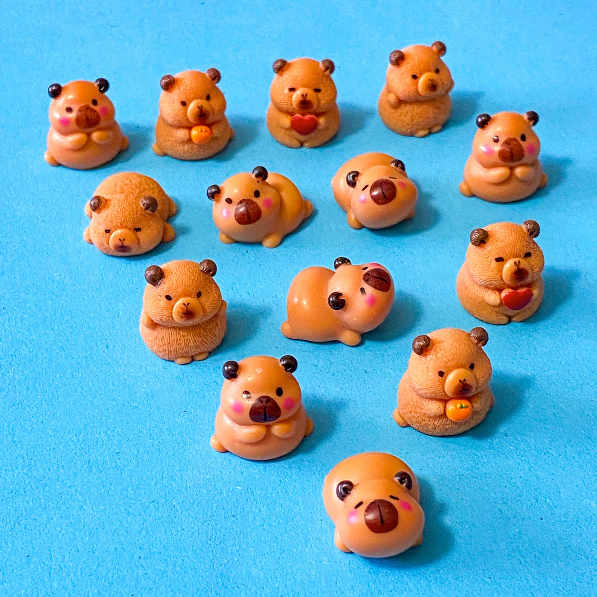 resin 3D miniature capybara figurines with oranges, hearts and cute expressions. Set of 3 different animals i9n organza bag