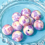 colourful pink lilac and pale yellow soft round floral silicone beads on a blue background