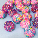 glittery jumbo beads in pinks and purple on a blue background