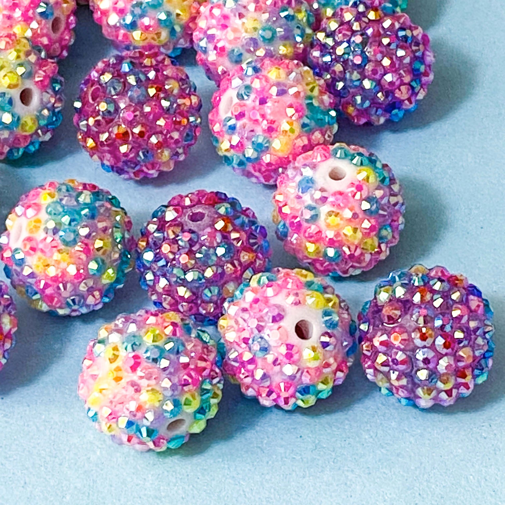 multicoloured sparkly rhinestone pave beads on a blue background