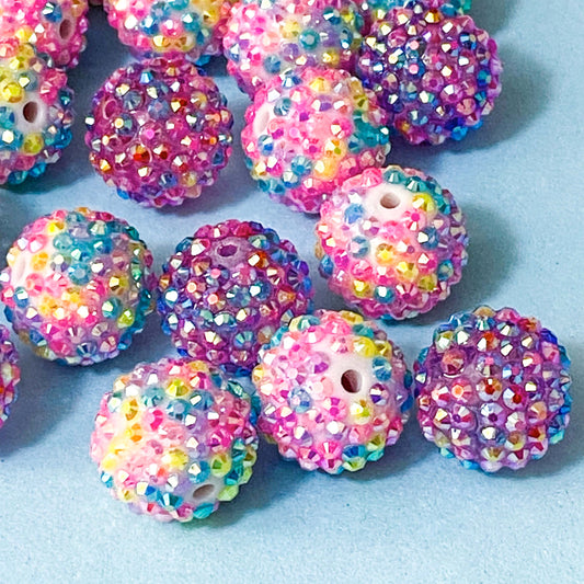 multicoloured sparkly rhinestone pave beads on a blue background