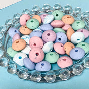 pastel silicone spacer beads with speckled pattern on a blue background