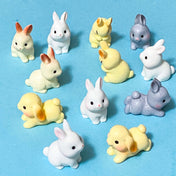 Set of small rabbit resin 3D figurines in various colours on a blue background