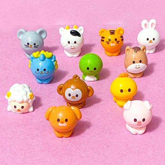 year of the Chinese zodiac animal miniature figurines on a pink background