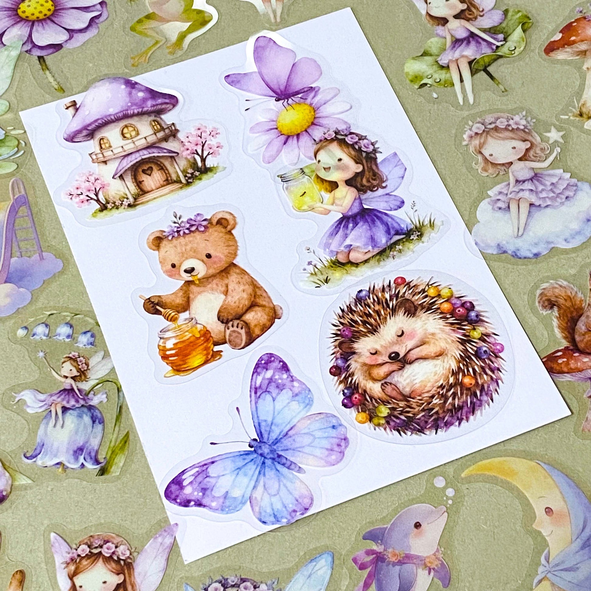 collection of 50 different pastel storybook stickers featuring fairies, woodland animals, flowers, castles, moons and butterflies and enchanted cottagecore illustrations in soft lilac and lavender tones.
