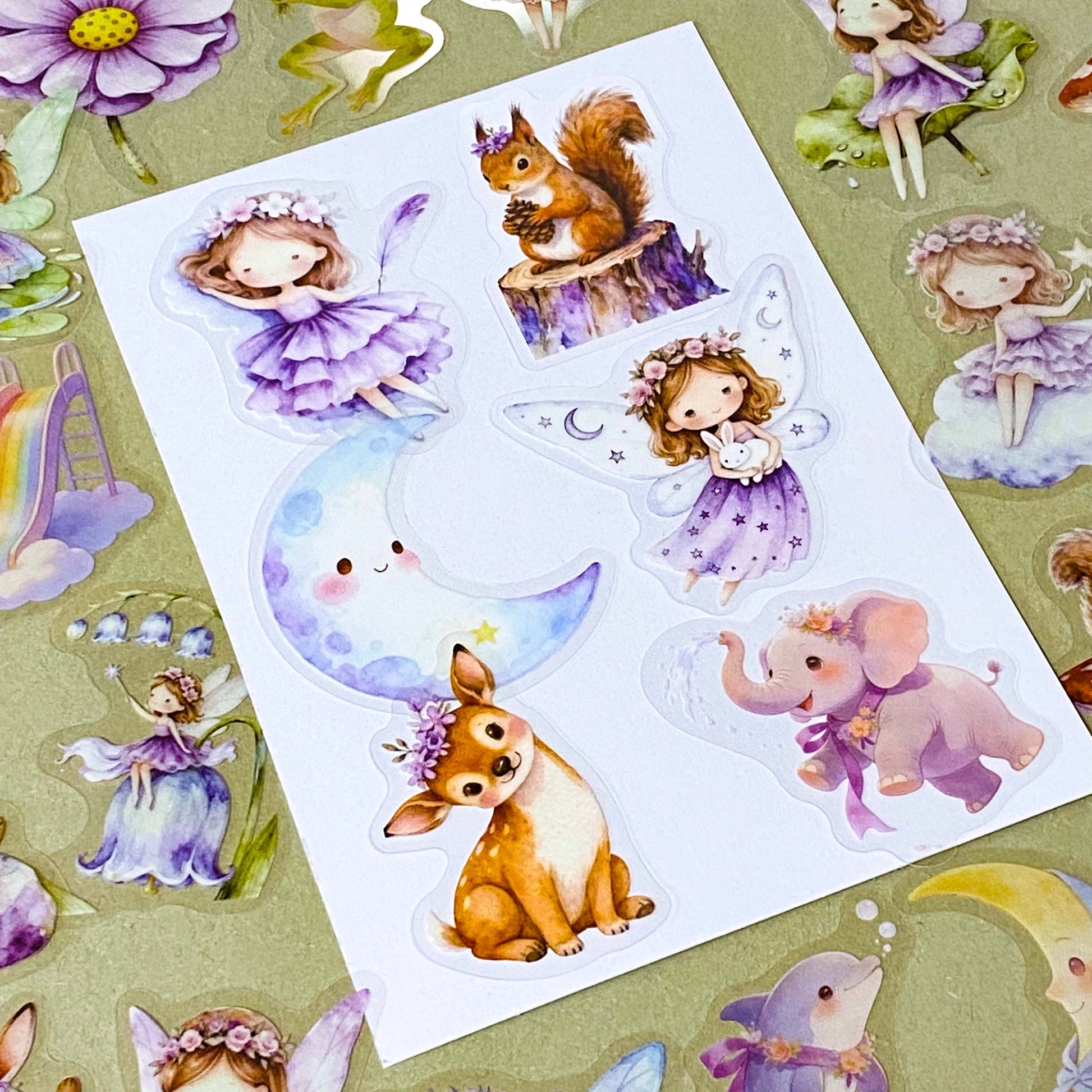 collection of 50 different pastel storybook stickers featuring fairies, woodland animals, flowers, castles, moons and butterflies and enchanted cottagecore illustrations in soft lilac and lavender tones.