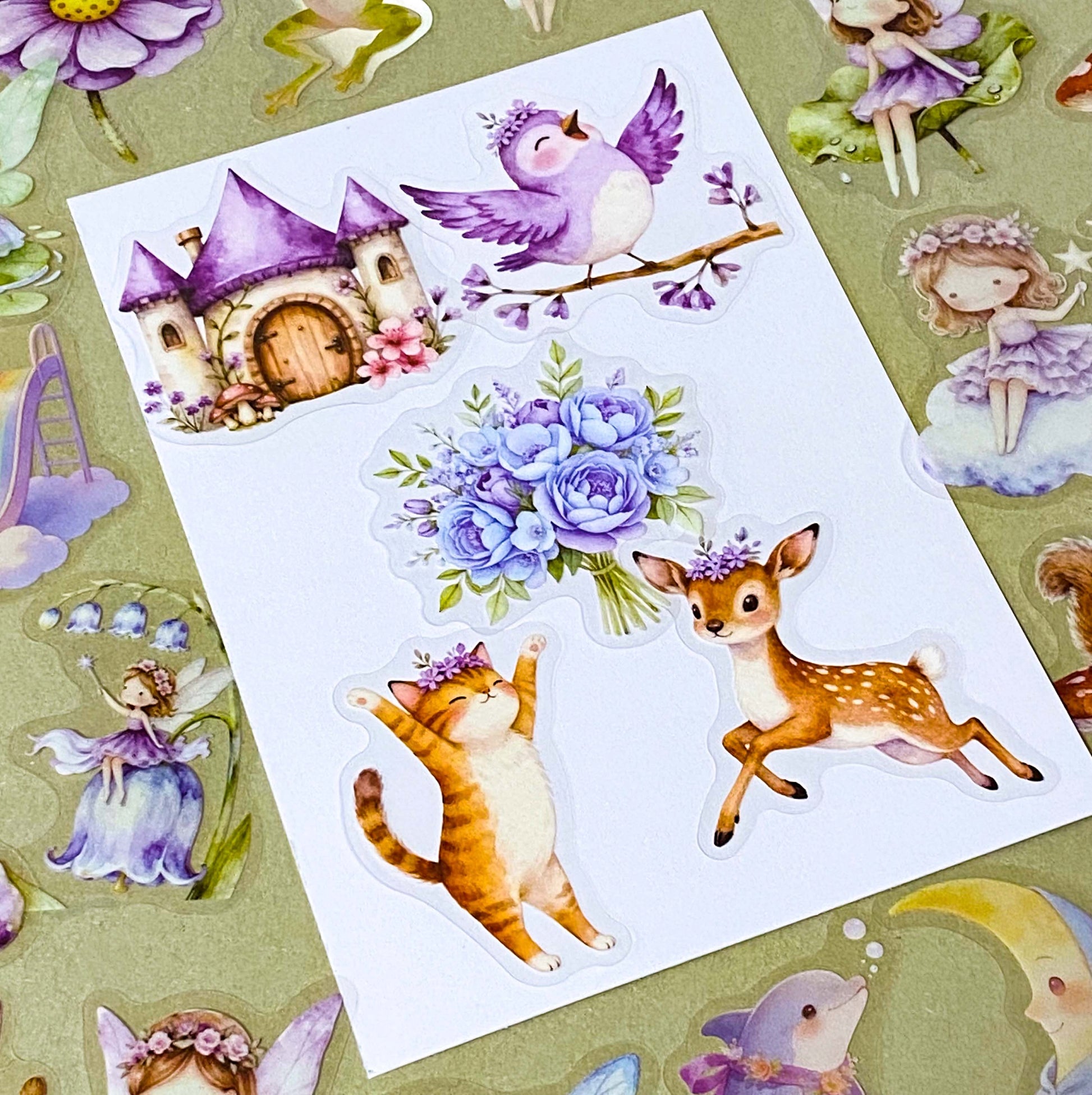 collection of 50 different pastel storybook stickers featuring fairies, woodland animals, flowers, castles, moons and butterflies and enchanted cottagecore illustrations in soft lilac and lavender tones.