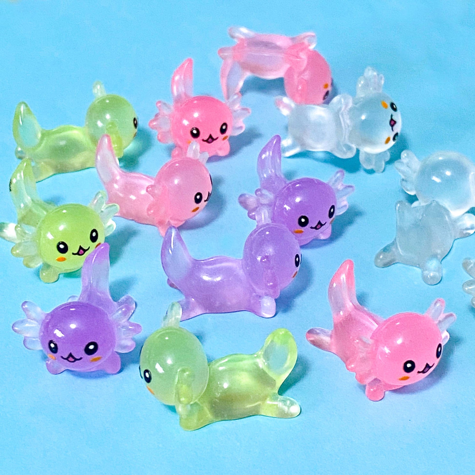 small pastel resin axolotl figurine miniatures in pink, lime green, clear and purple. 25mm long.