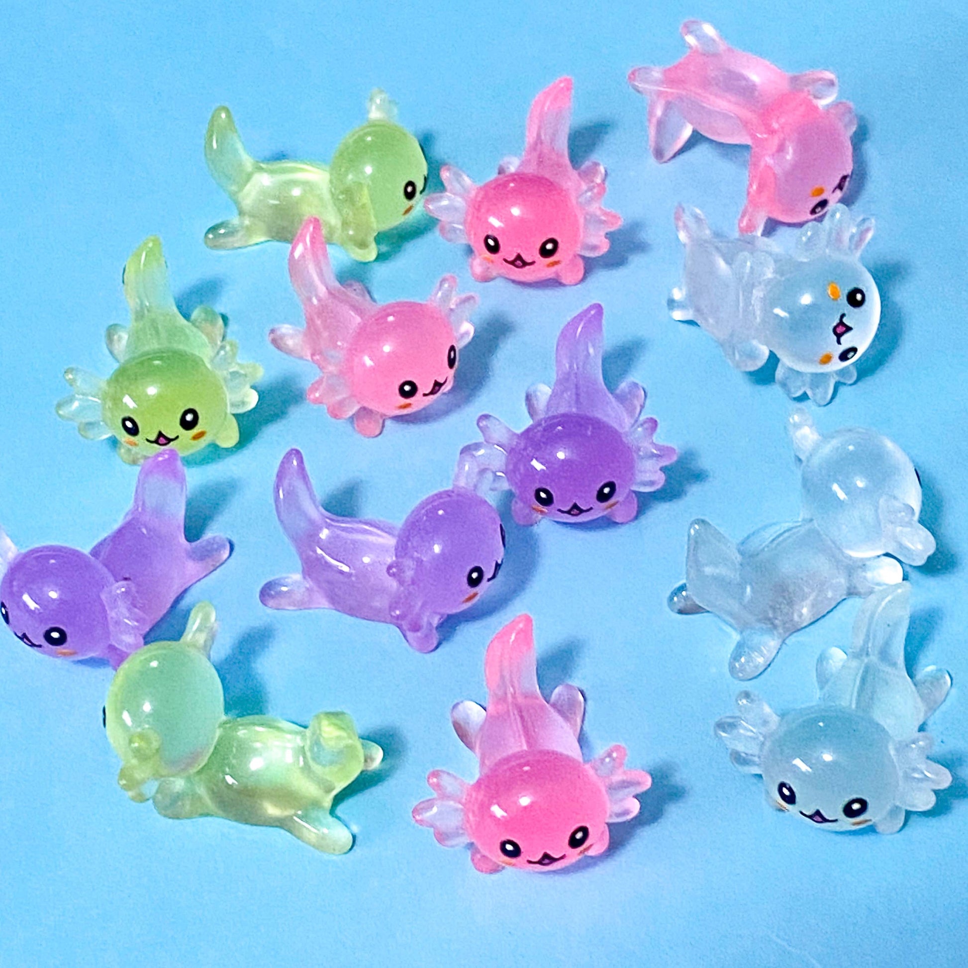 small pastel resin axolotl figurine miniatures in pink, lime green, clear and purple. 25mm long.