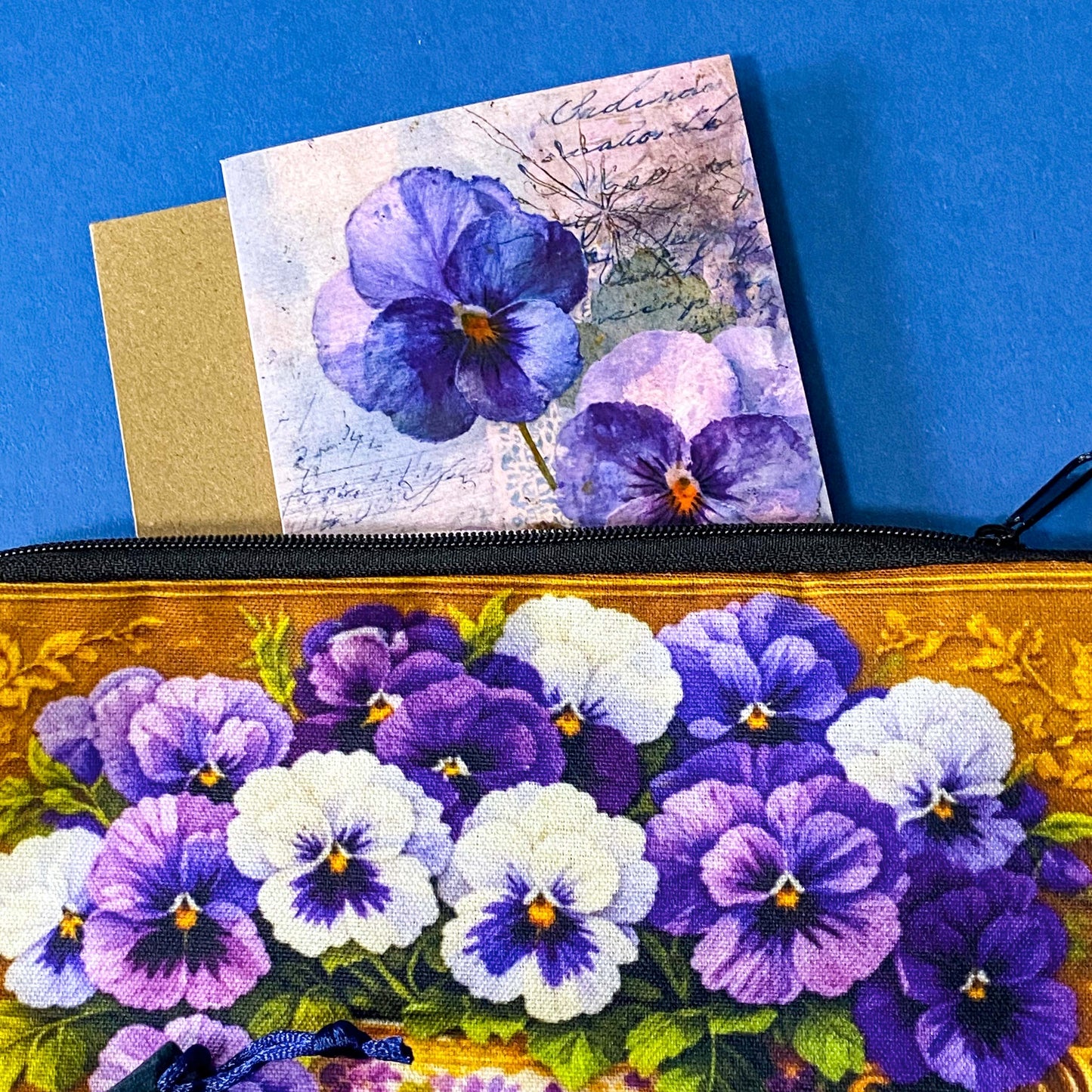 golden floral fabric pouch featuring purple and white pansies in a vintage teacup with matching enamel and metal rhinestone brooch in velvet gift bag and coordinating pansy greeting card with kraft envelope.