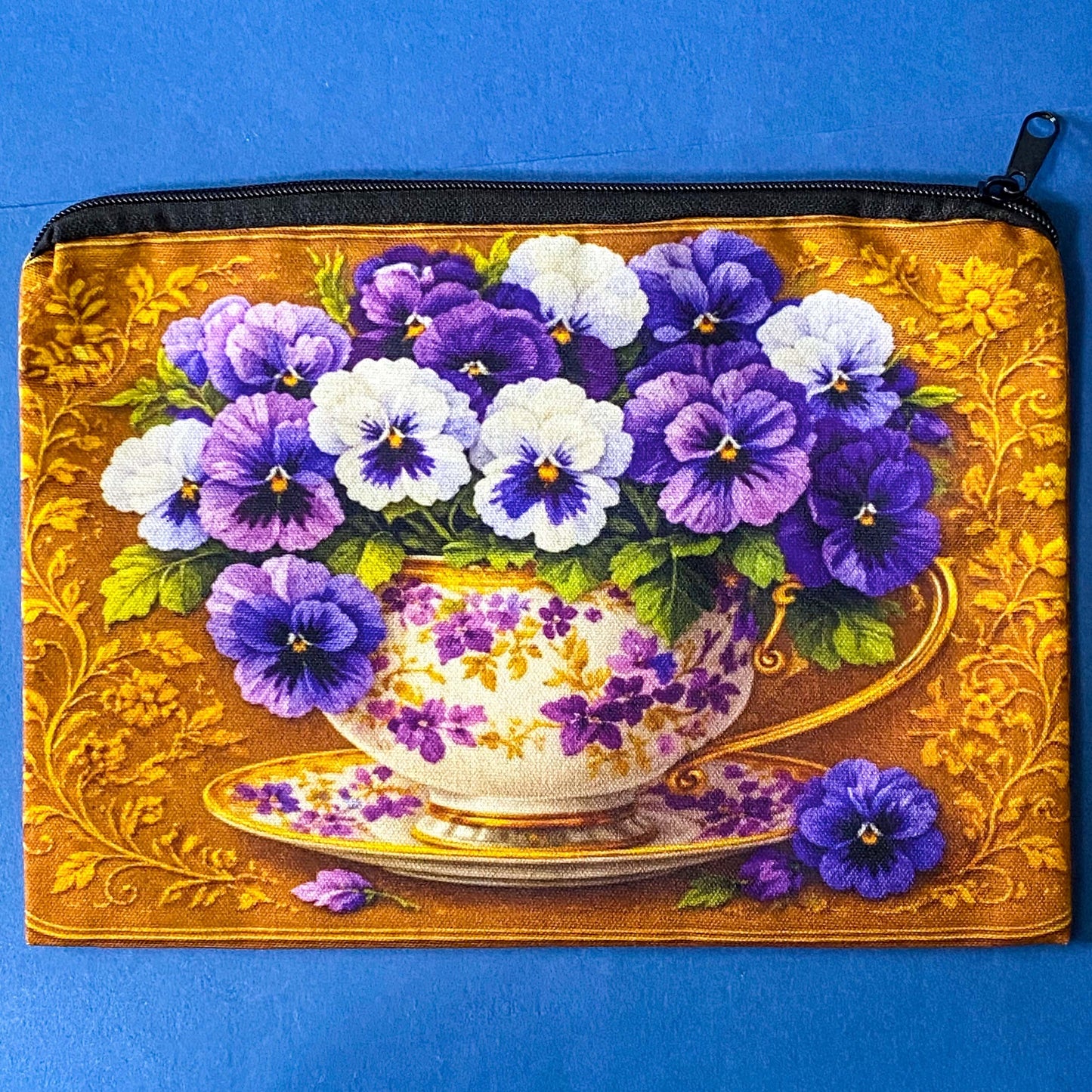 golden floral fabric pouch featuring purple and white pansies in a vintage teacup with matching enamel and metal rhinestone brooch in velvet gift bag and coordinating pansy greeting card with kraft envelope.