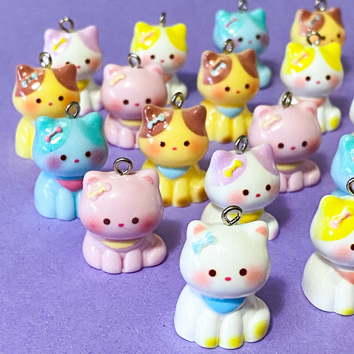 adorable pastel chunky cat resin charms in pink, blue, white and yellow with silver tone metal hooks and cute faces. 23mm to 26mm tall. uk craft supplies and jewellery making.